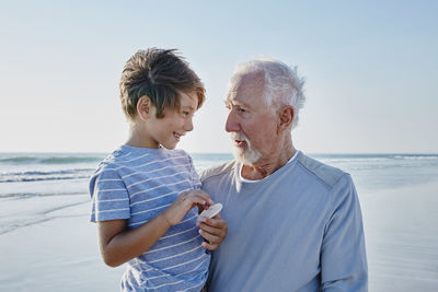 Grandfather with grandson on the beach