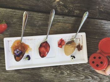 Directly above view of peanut butter and strawberries in spoons on plate