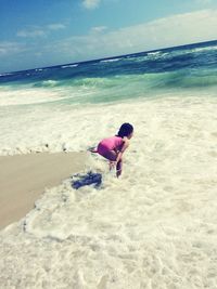 Full length of boy on beach against sky