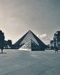 Buildings in city against cloudy sky