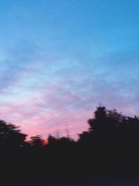 Low angle view of silhouette trees against romantic sky