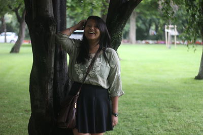 Woman standing on grassy field in park