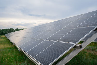 Solar panels on field against sky