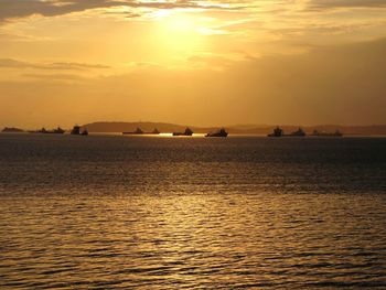 View of fishing boats on sea at sunset