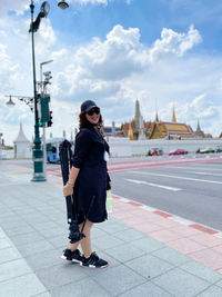 Full length of young woman on sunglasses against sky