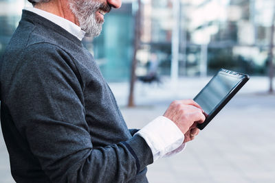 Midsection of businessman using mobile phone