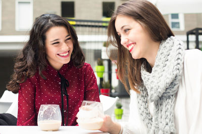 Happy young woman with coffee at cafe