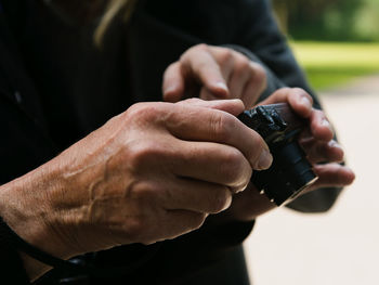 Midsection of person holding camera