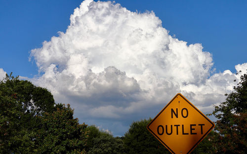 Low angle view of road sign against sky