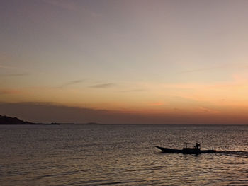 Silhouette boat in sea against sky during sunset