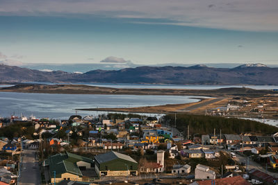 High angle view of town by lake against sky