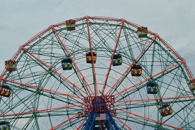 Low angle view of ferris wheel against sky in coney island.