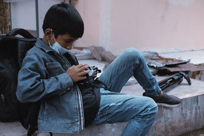 Rear view of boy using mobile phone