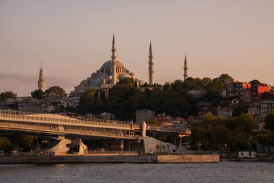 Bridge by sea against historic mosque in city