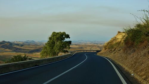 Road amidst trees against sky