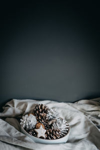 Close-up of pine cones and walnuts in bowl on table during christmas