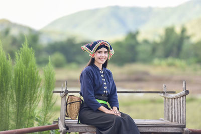 Portrait of smiling young woman sitting outdoor