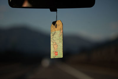 Close-up of information sign hanging in car