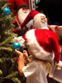 Rear view of little girl looking at  the toy on a christmas tree