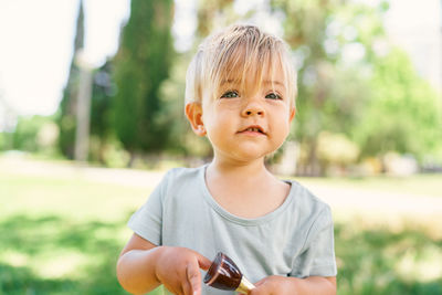 Portrait of cute boy holding camera