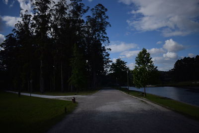 Road amidst trees against sky