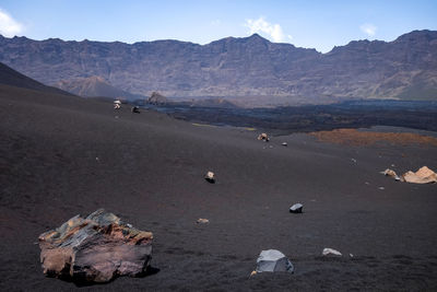 Scenic view of land and mountains against sky