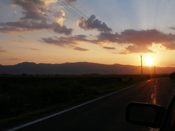 Road passing through mountains during sunset