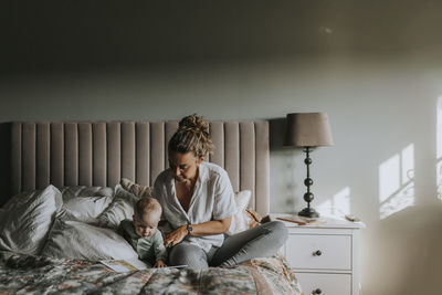 Mother reading to baby in bed