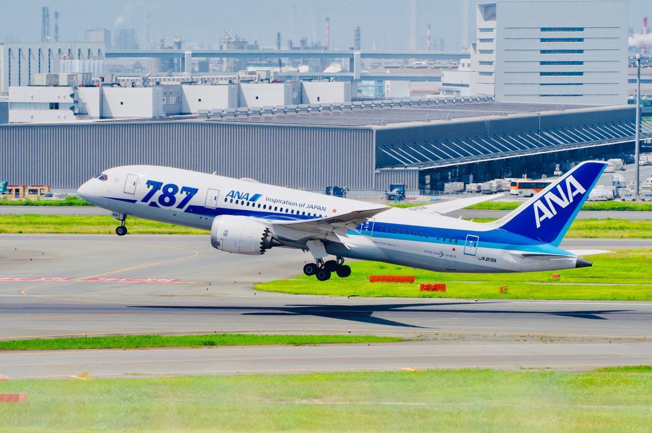 SIDE VIEW OF AIRPLANE ON AIRPORT RUNWAY