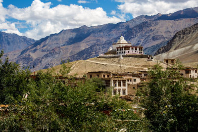Scenic view of houses and mountains against sky