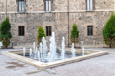 Fountain by building in city