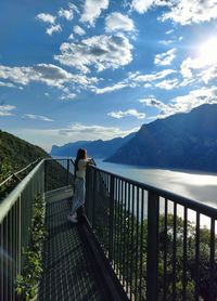 Girl on the bridge looking at lake panorama