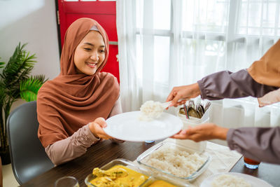 Cropped hands pf woman serving food at home