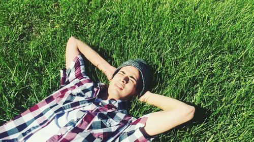 Low section of woman lying on grassy field