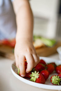 Midsection of child holding fruits