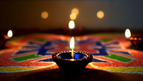 Close-up of lit diya against black background