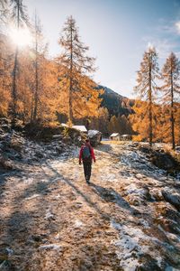 Rear view of woman walking on footpath during winter