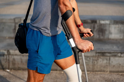 Young latin man with crutches visiting the city