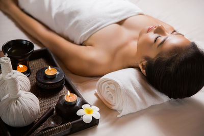 High angle view of young woman sleeping on bed at spa