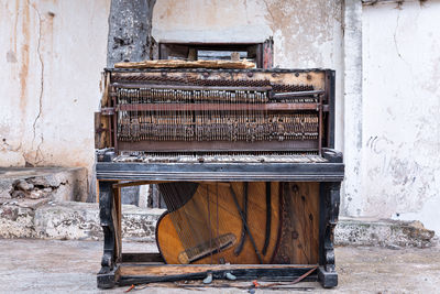 General view of an old and broken piano with a very antique look lying on the street