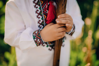 Midsection of boy holding stick