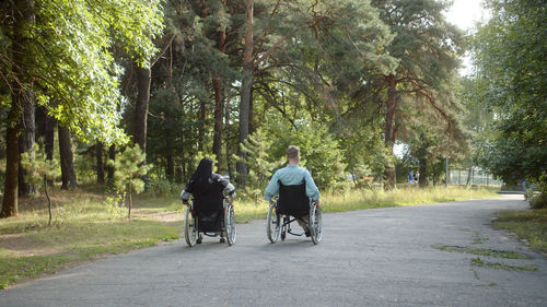 Rear view of man riding bicycle on road