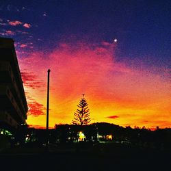 Silhouette buildings against sky at night