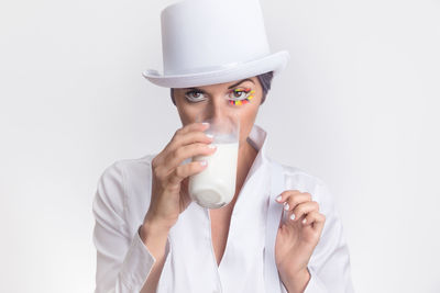 Portrait of mid adult woman wearing hat against white background