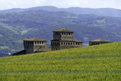 Built structure on field by mountains