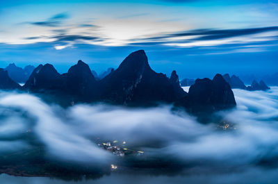 Scenic view of sea and mountains against sky