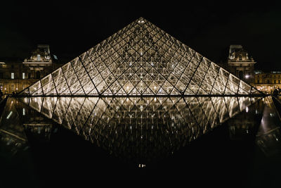 Low angle view of illuminated building against sky at night