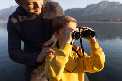 Father and boy exploring by lake