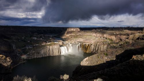 Scenic view of waterfall against sky