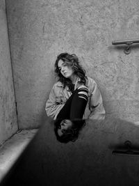 Young woman sitting on wall